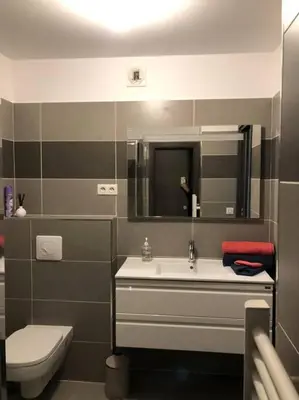 a bathroom with a sink and a toilet and a mirror at T2 récent climatisé à 100m du port in Propriano