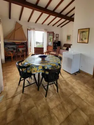 a living room with a table and chairs and a piano at Maison Les couchants Porticcio in Porticcio