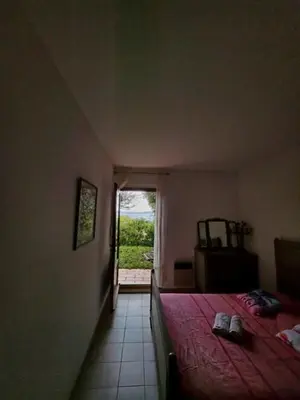 a bedroom with a bed with a red blanket and a window at Maison Les couchants Porticcio in Porticcio