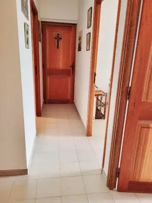 a hallway with a wooden door and a tile floor at Maison Les couchants Porticcio in Porticcio