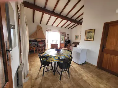a dining room with a table and chairs in a room at Maison Les couchants Porticcio in Porticcio