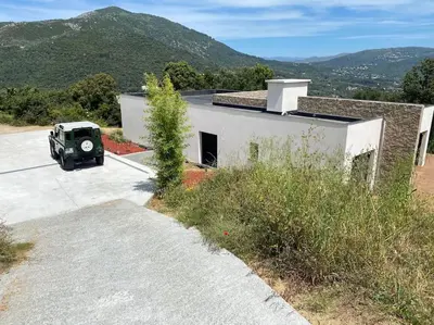 a car parked in a parking lot next to a building at Villa d'Architecte Casa Mado avec Piscine vue imprenable in Ajaccio