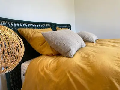 a bed with yellow sheets and pillows on it at Villa d'Architecte Casa Mado avec Piscine vue imprenable in Ajaccio