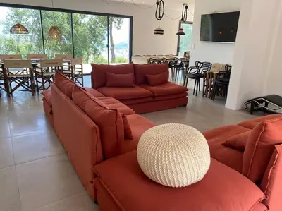 a living room with two red couches and a table at Villa d'Architecte Casa Mado avec Piscine vue imprenable in Ajaccio