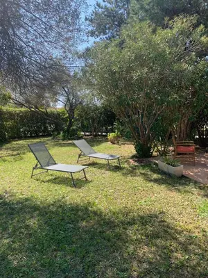 two chairs sitting in the grass in a yard at VILLA Bord de Mer in Cervione