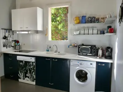 a kitchen with a washing machine and a sink at Corse Piana villa d’architecte vue exceptionnelle in Piana