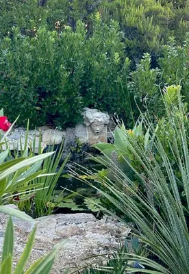 a couch sitting next to a table in a garden at Corse Piana villa d’architecte vue exceptionnelle in Piana
