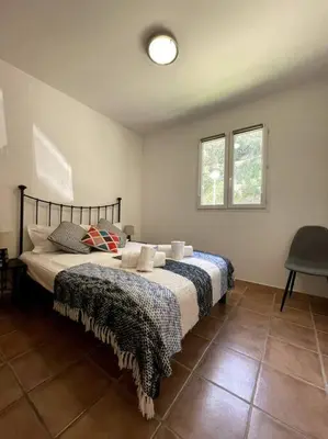 a bedroom with a bed and two windows at Résidence Kallisté in Sollacaro
