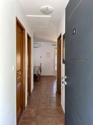 a hallway with a tile floor and a blue door at Résidence Kallisté in Sollacaro