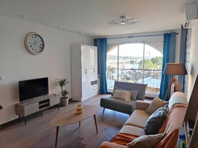 a living room with a couch and a tv at Appartement sur le port Résidence Marina Palmu in Porto-Vecchio