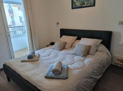 a bed with two pillows and two books on it at Appartement sur le port Résidence Marina Palmu in Porto-Vecchio