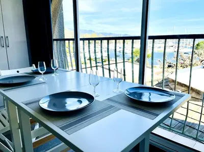 a white table with wine glasses and a view of the ocean at Appartement sur le port Résidence Marina Palmu in Porto-Vecchio