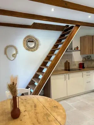 a kitchen with a wooden table and a spiral staircase at Maison Casa Amarina in Olmeto