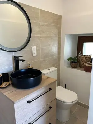 a bathroom with a sink and a toilet and a mirror at Maison Casa Amarina in Olmeto