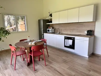 a kitchen and living room with a table and a kitchen and a dining room at Chez François et Cécile in Figari