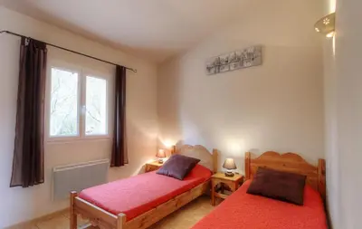 a bedroom with two beds and a window at Les bergeries d'Ogliastrello in Figari