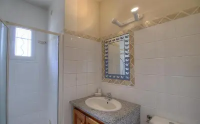 a bathroom with a sink and a mirror at Les bergeries d'Ogliastrello in Figari