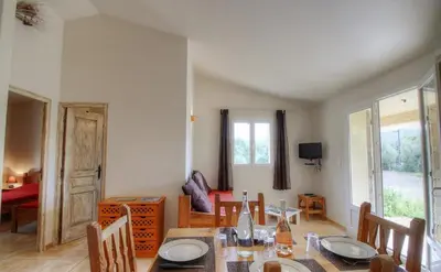 a dining room with a table and chairs and a room at Les bergeries d'Ogliastrello in Figari