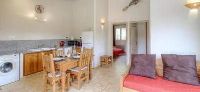 a kitchen and living room with a table and a couch at Les bergeries d'Ogliastrello in Figari