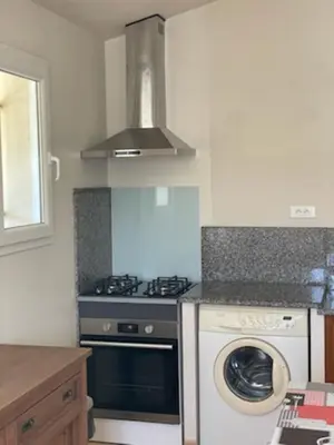 a kitchen with a stove and a washing machine at Les bergeries d'Ogliastrello in Figari
