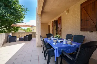 a blue table and chairs on a patio at La Caletta Corsa Apartments - 2 Camere con Terrazza Privata, Aria Condizionata, 100m dal Mare in Linguizzetta