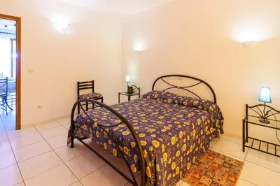 a bedroom with a bed and two chairs at La Caletta Corsa Apartments - 2 Camere con Terrazza Privata, Aria Condizionata, 100m dal Mare in Linguizzetta