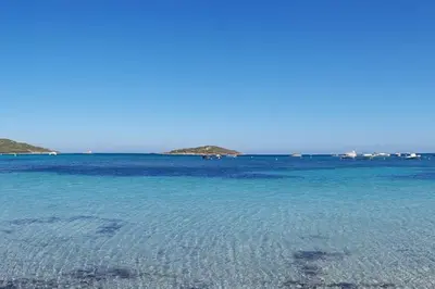 a large body of blue water with islands in the background at T2 neuf 4 personnes avec piscine/terrain tennis in Porto-Vecchio