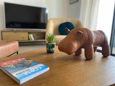 a wooden elephant on a table next to a book at T2 neuf 4 personnes avec piscine/terrain tennis in Porto-Vecchio