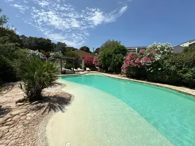 a swimming pool in a yard with trees and flowers at Luxueuse Villa, Hyper centre PORT de PORTO VECCHIO in Porto-Vecchio