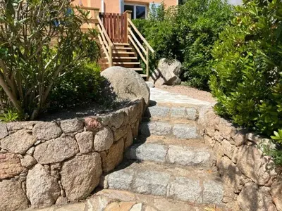 a stone path with a stone wall and stairs at Luxueuse Villa, Hyper centre PORT de PORTO VECCHIO in Porto-Vecchio