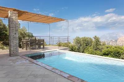 a house with a swimming pool and a table at Les Demeures de Piana in Piana