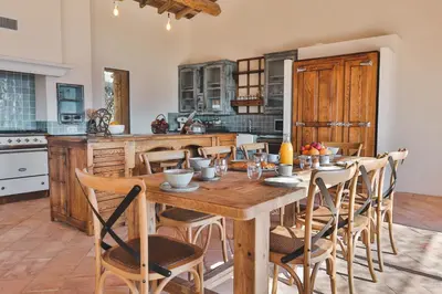 a large kitchen with a wooden table and chairs at Les Demeures de Piana in Piana