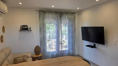 a living room with a television and a couch at Chez Baptiste et Laura in Figari