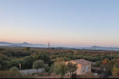a house in the middle of a field with a windmill at Chez Baptiste et Laura in Figari
