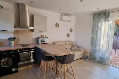 a kitchen with a table and chairs in a room at Chez Baptiste et Laura in Figari