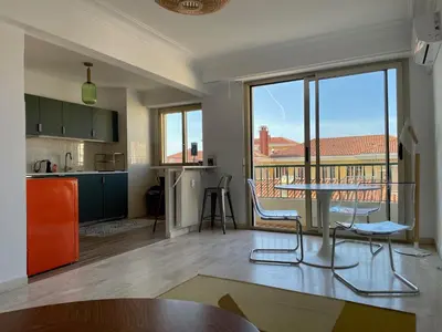 a kitchen and living room with a table and chairs at Spacieux 2 pièces Centre Historique Ajaccio in Ajaccio