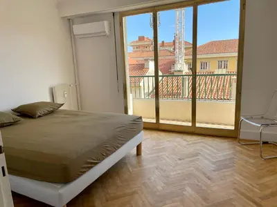 a bedroom with a bed and a large window at Spacieux 2 pièces Centre Historique Ajaccio in Ajaccio