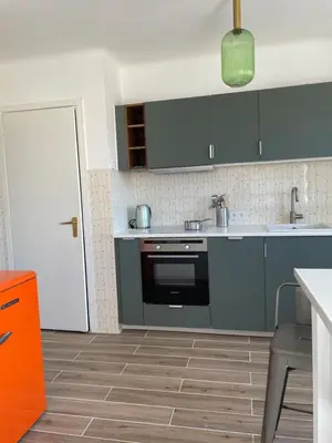 a kitchen with gray cabinets and a black oven at Spacieux 2 pièces Centre Historique Ajaccio in Ajaccio