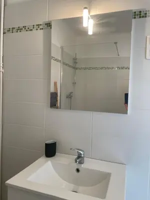 a white bathroom with a sink and a mirror at Spacieux 2 pièces Centre Historique Ajaccio in Ajaccio