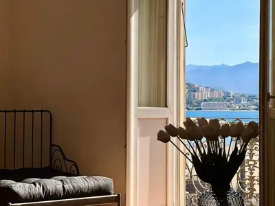 a vase with flowers in a room with a window at Casamea - Vue Mer, Centre Ajaccio, Clim & WiFi in Ajaccio