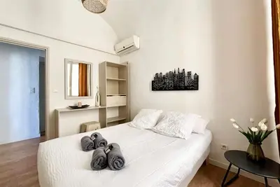 a bedroom with a white bed with towels on it at Casamea - Vue Mer, Centre Ajaccio, Clim & WiFi in Ajaccio