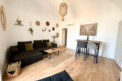 a living room with a black couch and a table at Casamea - Vue Mer, Centre Ajaccio, Clim & WiFi in Ajaccio