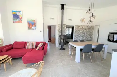 a living room with a red couch and a table at Casa Vecchia Di Olmuccio in Sainte-Lucie de Porto-Vecchio