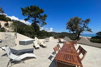 a patio with wooden tables and chairs and trees at Casa Vecchia Di Olmuccio in Sainte-Lucie de Porto-Vecchio
