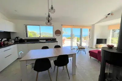 a kitchen and living room with a table and chairs at Casa Vecchia Di Olmuccio in Sainte-Lucie de Porto-Vecchio