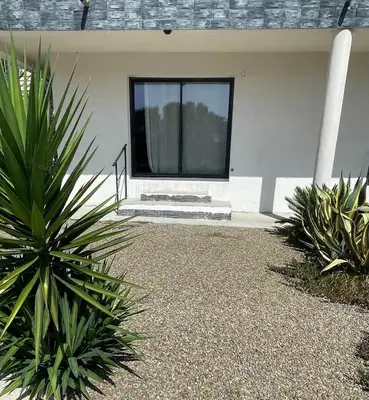 a house with a window and some plants at U Secondu Appart neuf spacieux au calme in Aléria