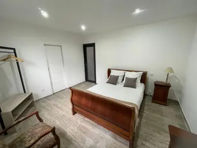 a bedroom with a bed and a chair at U Secondu Appart neuf spacieux au calme in Aléria