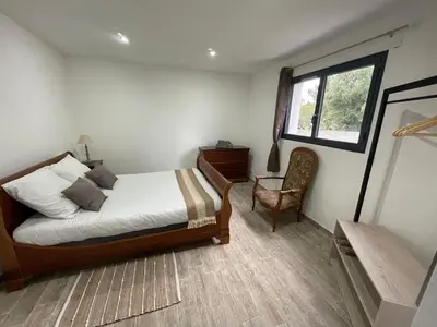 a bedroom with a bed and a chair and a window at U Secondu Appart neuf spacieux au calme in Aléria