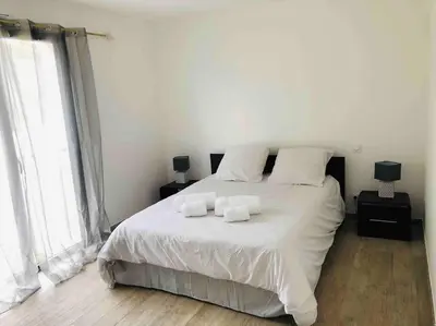 a bedroom with a white bed with two towels on it at U Primu Appartement spacieux au calme Aléria in Aléria