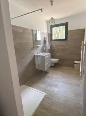 a bathroom with a sink and a toilet and a window at U Primu Appartement spacieux au calme Aléria in Aléria